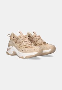 Zapatillas deportivas beige con una parte superior de malla, adornadas con rhinestones, cuentan con una suela blanca gruesa y una suela exterior de goma texturizada.