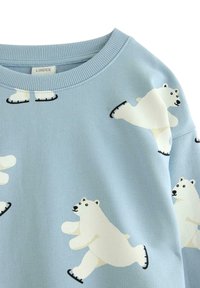Hellblauer Pullover mit weißen Eisbären auf Schlittschuhen. Gerippter Halsausschnitt und glatte Textur mit mehreren verspielten Bärenillustrationen.