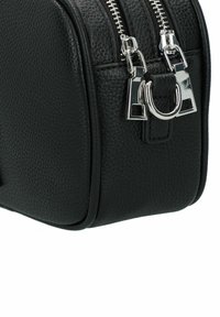 Borsa in pelle nera con superficie testurizzata, doppie cerniere argentate e un accento metallico. Presenta una forma strutturata e un design elegante.