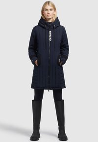 Navy padded long coat with a hood, featuring a zipper, elastic cuffs, and side pockets. Designed with vertical stitching and branding detail.