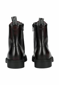 Botines de cuero negro con acabado liso, con cremalleras laterales, suela texturizada y plantillas en gris contrastante.