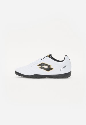 White sports shoes with black and yellow accents, featuring a textured upper, round toe, and a black rubber sole. The design includes a logo detail on the side.
