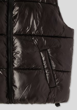 Gilet imbottito nero realizzato in materiale lucido e trapuntato. Presenta una chiusura lampo completa, una tasca laterale e un cordino elastico in fondo.
