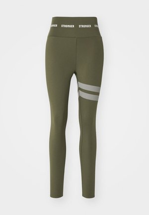 Olijfgroene leggings van rekbaar materiaal, met een hoge tailleband waarop de tekst "STRONGER" staat en drie horizontale mesh-strepen op de dij.