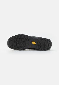 Czarne buty trekkingowe z wytrzymałą gumową podeszwą o głębokich bieżnikach, logo Vibram oraz teksturowanym wierzchem dla lepszej przyczepności.