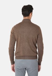 Maglione di lana marrone con colletto alto e polsini a costine, caratterizzato da una silhouette aderente e una superficie testurizzata. Vista posteriore semplice, senza motivi visibili.