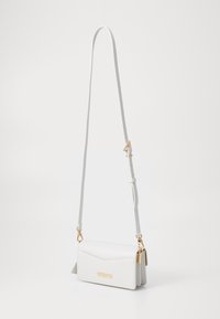 Sac à bandoulière en cuir blanc avec un design plié, matériel doré, bandoulière ajustable et forme rectangulaire. Présente une texture subtile et une plaque.