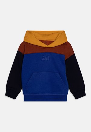 Sweat à capuche enfant avec capuche jaune moutarde, empiècement aux épaules marron rouille, poitrine et corps bleus, manches noires, avec une poche avant et le logo GAP.