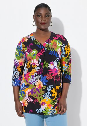 Tunique florale colorée avec un col en V et des manches trois-quarts, composée d'un tissu doux avec un fond noir et des motifs vibrants.