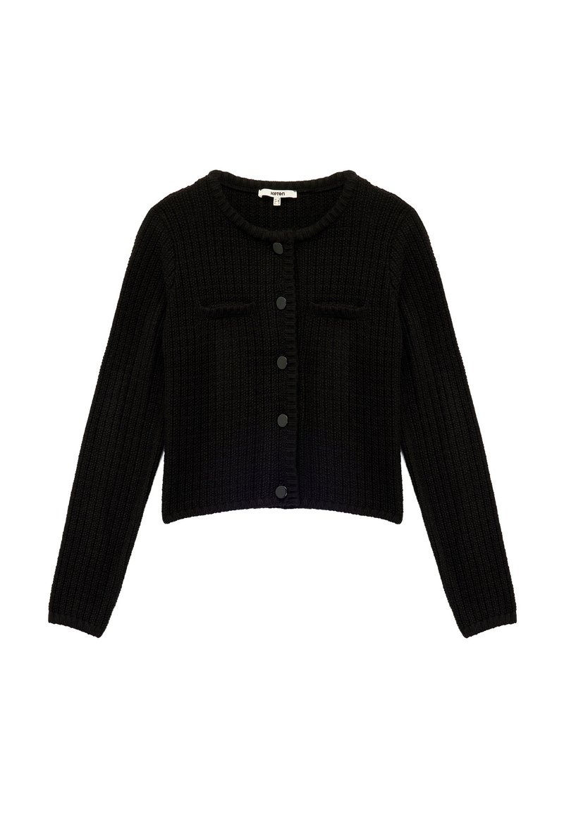 Schwarze kurze Strickjacke aus strukturierter Rippstrickware mit rundem Hals, durchgehender Knopfleiste und zwei aufgesetzten Taschen. Mit schwarzen Knöpfen ausgestattet.