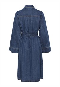 Džínsové šaty s opaskom na viazanie na chrbte, dlhými rukávmi a golierom. Majú strednú dĺžku a kontrastné stehy.