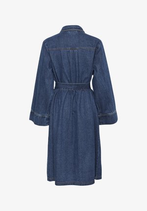 Denimmekko, jossa on takana solmittava vyö, pitkät hihat ja kauluskokonaisuus. Ominaisuuksiin kuuluu puolipitkä muotoilu ja erottuva tikkaus.