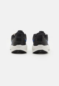 Black athletic shoes with blue accents, made from mesh and synthetic materials, featuring a cushioned white sole and heel tab for easy wear.