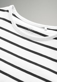 Weißes T-Shirt aus Stoff mit gleichmäßig verteilten schwarzen horizontalen Streifen, mit einem runden Halsausschnitt und einem Etikett, auf dem steht "THE SET, MADE IN BANGLADESCH."