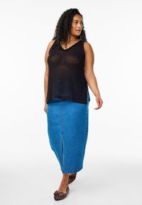 Svart nät ärmlös topp med V-hals, ihop med en blå denim maxikjol med en framslits och leopardmönstrade ballerinaskor.