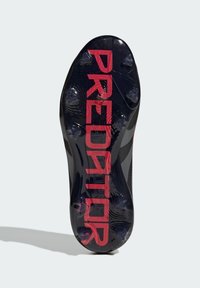 Black football cleat with a textured sole, featuring prominent pink "PREDATOR" branding and raised studs for traction.