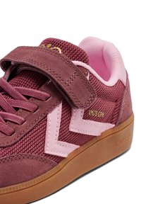 Bordeauxrote und pinke Sneaker mit einem Mesh-Obermaterial, Wildlederelementen, einem Klettverschluss und einer Gummisohle mit einer gumifarbenen Unterseite.