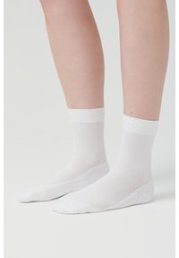 White ankle socks with a ribbed cuff, made from a smooth, stretchy fabric, featuring reinforced toe and heel areas for durability.