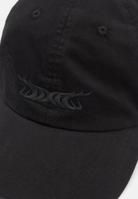 Fekete pamut sapka ívelt karimával, varrott panelekből és egy érdes fekete hímzett logóval az elején.