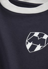 Camiseta azul marino con cuello redondo blanco y mangas cortas, que presenta un gran logotipo geométrico en blanco y negro. Tejido suave y texturizado.