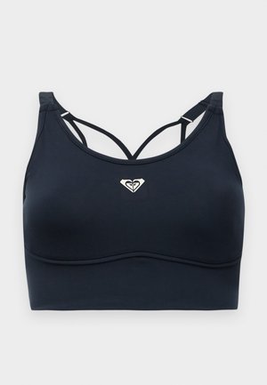 Reggiseno sportivo nero con una texture liscia, caratterizzato da un collo rotondo, spalline incrociate e un piccolo logo argentato al centro.