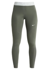 Nike Pro leggings in oliivivihreä, joissa on valkoinen elastinen vyötärö, tyylikäs muotoilu, sileä rakenne ja kontrastiväriset sivupaneelit.