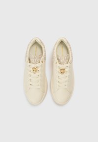 Bež tenisice s gornjim dijelom od glatke kože, uzorkovanim tekstilnim okovratnikom, hardverom u zlatnoj boji i bijelim vezicama. Na bočnoj strani istaknut je prepoznatljivi MK logo.