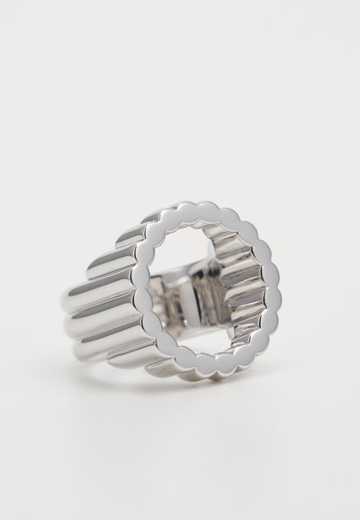 Silver ring with a fluted texture and scalloped edges. Features an open center, reflecting light with a shiny finish. Simple geometric design.
