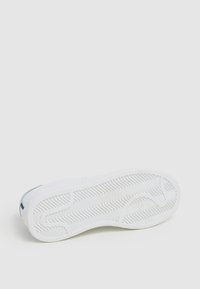 Sole di sneaker bianca con un motivo di battistrada ondulato, texture liscia e tallone rinforzato. Presenta un design minimalista senza loghi o accenti visibili.