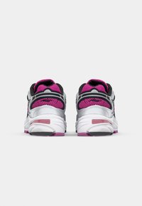 Scarpe da corsa con una tomaia in rete nera, accenti grigi, dettagli rosa e una suola bianca con un design testurizzato e dettagli del logo.