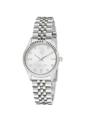 Montre-bracelet en métal argenté avec un cadran blanc rond, des index en cristal et un bracelet métallique maillé. Le cadran affiche le logo et le texte de U.S. Polo Assn.