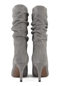 Bottes à talons aiguilles en cuir suédé gris avec un design ample et un bout pointu. Elles présentent une texture lisse et un fin talon stiletto noir.