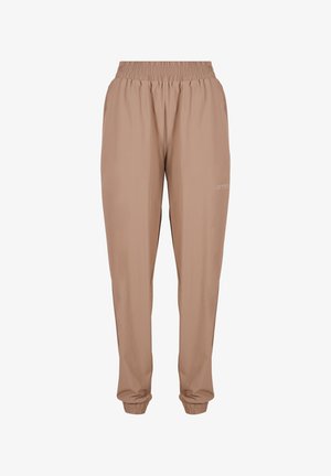 Zbliżenie na dłoń w kieszeni beżowych, casualowych spodni z elastycznym pasem i logo „aimn” na udzie.