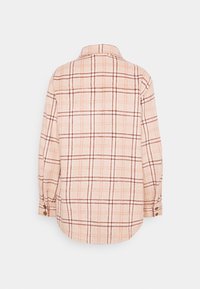 Camicia button-up in morbido tessuto a quadri. Base pesca chiaro con linee marroni e arancioni scure. Presenta un colletto e polsini con bottone.