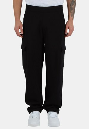 Pantaloni cargo neri con vestibilità rilassata, molteplici tasche laterali e vita con cordoncino. Realizzati in tessuto morbido con una texture liscia.