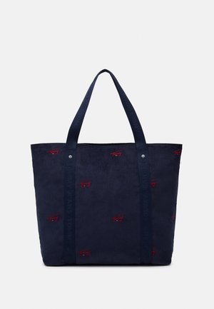 Marineblå kordfløjls-totetaske med to håndtag og små røde broderede logoer spredt på det ydre stof.