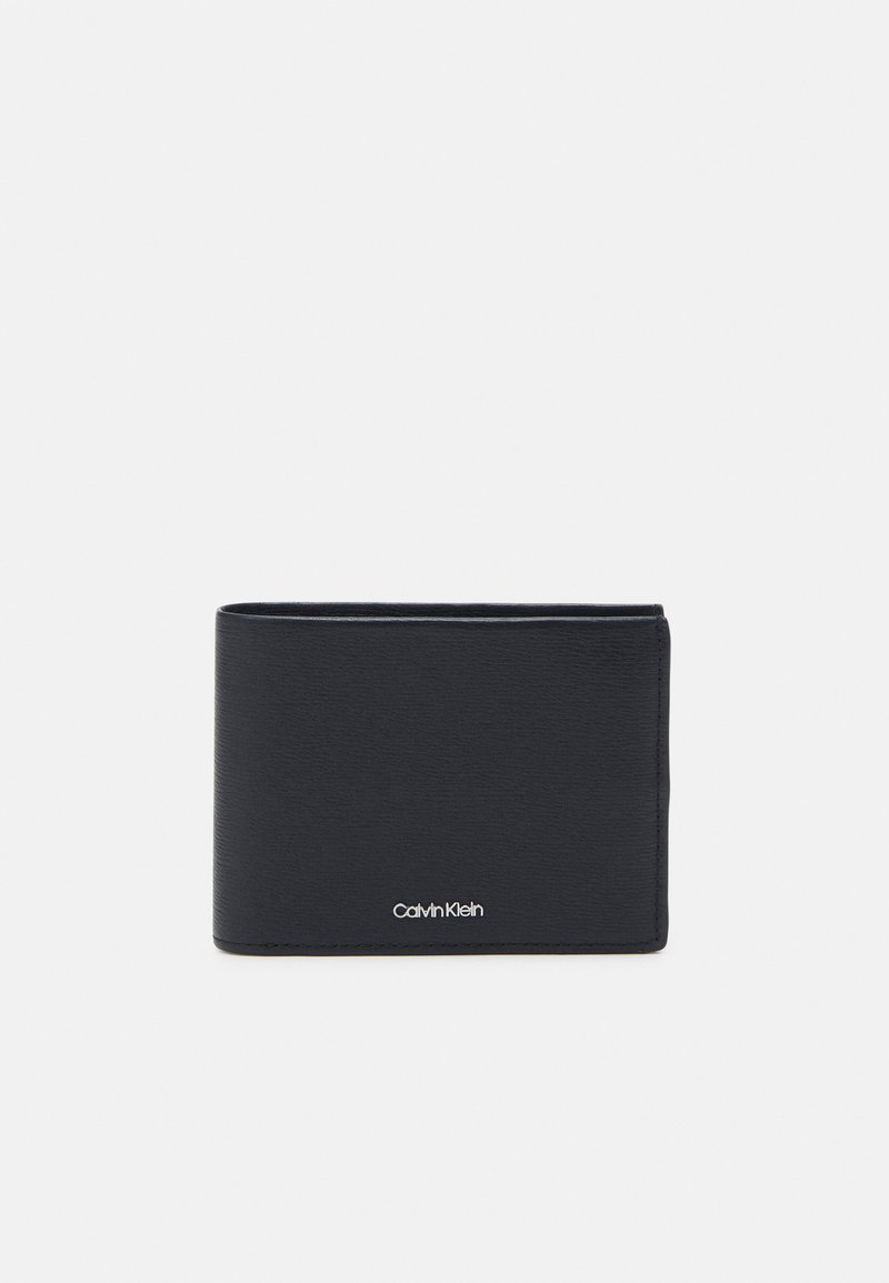 Must mustra nahkrahakott koos tekstureeritud pinnaga, kaheosaline disain ja nähtav Calvin Klein logo alumisel esiosas.