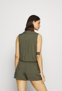 Olivengrüner ärmelloser Overall mit kragenfreiem Ausschnitt, Rückentaschen, elastischem Taillenbund und weichem Material, von hinten gezeigt.