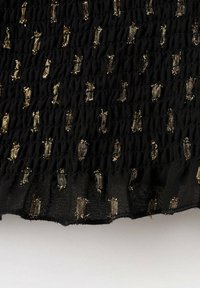 Tessuto nero testurizzato con sezioni arricciate, caratterizzato da accenti dorati in un motivo ripetitivo. Materiale morbido e leggero con orlo sfilacciato.