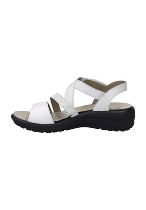 White sandals with multiple straps, featuring a shiny silver accent, a cushioned footbed, and a black rubber sole for stability.