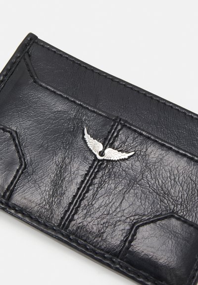 Black leather cardholder featuring a textured surface, angled stitching, and a silver winged emblem on the front. Compact rectangular shape.
