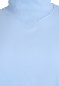 Lichtblauwe coltrui met een geribbelde structuur en een v-hals ontwerp. De stof lijkt zacht en glad.