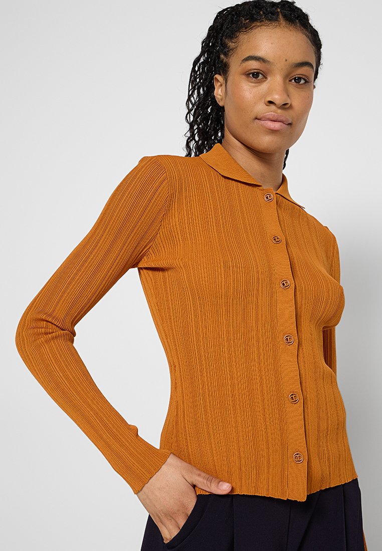 Rippstrick, langärmlige, durchgeknöpfte Strickjacke in warmem Orange. Verfügt über einen klassischen Kragen und dekorative Knöpfe. Weicher, strukturierter Stoff.