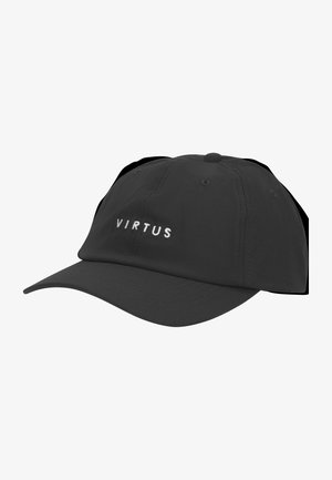 Homme portant une casquette de baseball noire avec le texte « VIRTUS » et un t-shirt noir à manches longues, regardant vers la gauche sur un fond blanc uni.