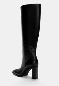 Knöchelhoher schwarzer Lederstiefel mit spitzem Zehen und einem stabilen Absatz. Glatte Textur mit einem eleganten, minimalistischen Design.