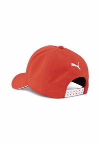Raudona beisbolo kepurė su išlenktu vizoriumi, pagaminta iš lygaus audinio. Ant jos yra baltas Puma logotipas ir raštuota juosta reguliuojamoje juostoje.