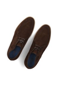 Chaussures en suede marron avec un design épuré, un bout arrondi et de subtils détails de couture ; les lacets sombres et la doublure intérieure bleue sont visibles.
