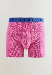 Caleçons boxers roses à motifs avec une ceinture élastique bleue portant l'inscription 'NEXT'. Le design géométrique comprend des lignes ondulées et des contours.