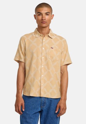 Camisa de botonadura de manga corta en color amarillo claro con un estampado geométrico en crema. Presenta un bolsillo en el pecho y un pequeño logo de la marca.