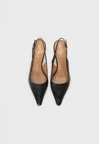 Sorte lærreder med spiss tå og slingback-heler med beige såler og gullfarget logo-tekst, vist side om side på en hvit bakgrunn.